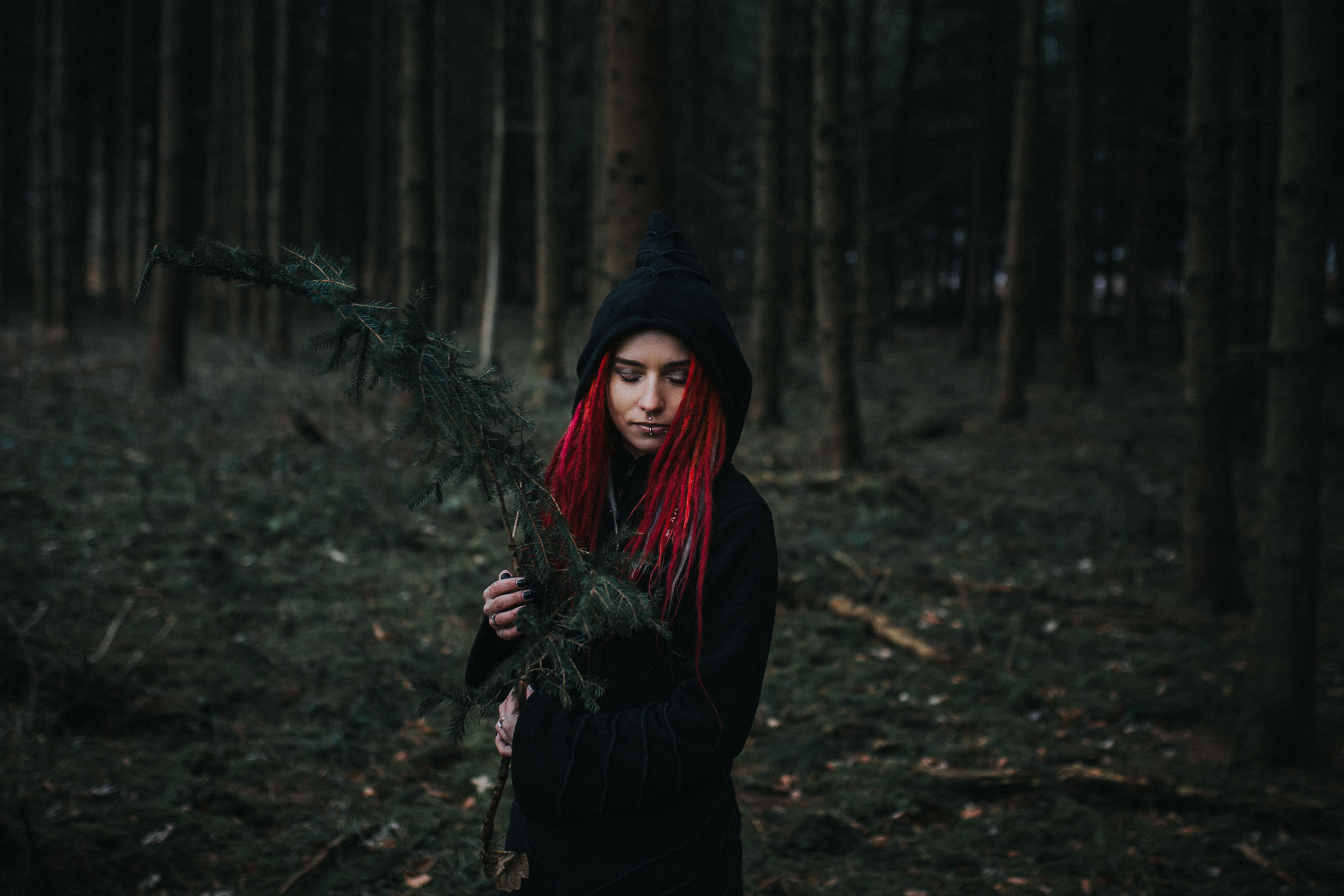 Stella hält einen Ast im Wald, Portrait